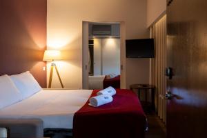 a hotel room with a bed with a towel on it at Hotel Rali Viana in Viana do Castelo