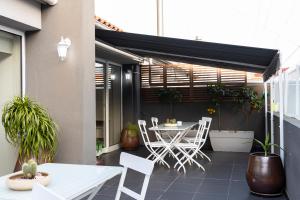 a patio with a white table and chairs and a table and chairsktop at Hotel Rali Viana in Viana do Castelo