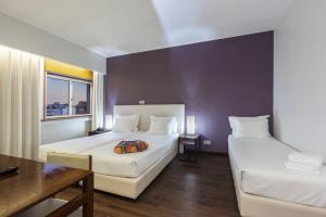 a hotel room with two beds and a table at Hotel Rali Viana in Viana do Castelo