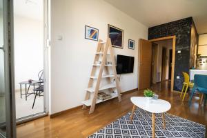 Sala de estar con escalera y mesa en Apartment sPARK Niš, en Niš