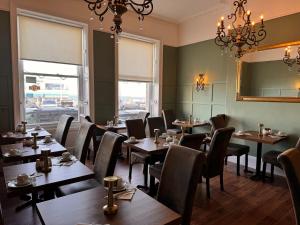a restaurant with wooden tables and chairs and windows at Marina Court in Weymouth