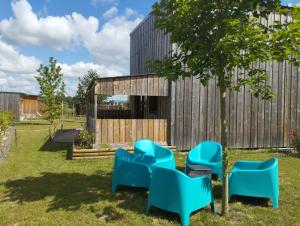 a group of blue chairs in front of a building at CHALET VINTAGE - Climatisé - Les Belles Ouvrières in Clermont-Créans