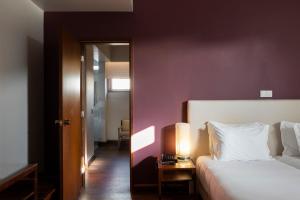 a bedroom with a bed and a lamp on a table at Hotel Rali Viana in Viana do Castelo