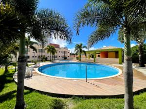 Pedro CanárioApides Palace Hotel Ltda的院子里有棕榈树的游泳池