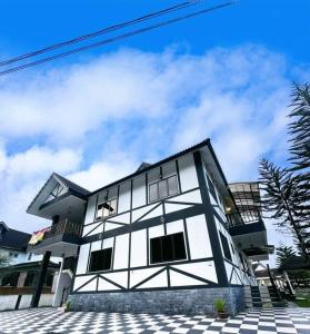 a white and black building with a sky at Bukit Cottage - bungalow style in Tanah Rata