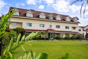 a large building with a green lawn in front of it at Midland Hotel Nakuru in Nakuru