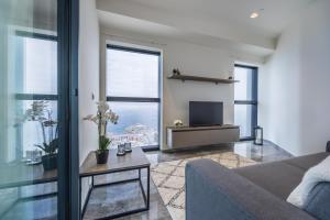 a living room with a couch and a tv at Apartment on Cloud Nine in Malta's Tallest Tower in St Julian's