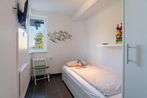 una piccola camera da letto con un letto e una sedia di Strandpark-Grossenbrode-Haus-Wolkenlos-Wohnung-5 a Grossenbrode