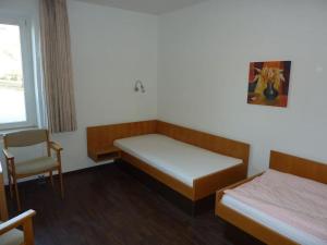 a room with two beds and a chair in it at Monteurwohnung 2 Zimmer 5 Betten, Küche, Bad, Waschmaschine in Uelzen