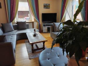 a living room with a couch and a table at maison de vacances chez louis in Sondernach