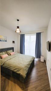 a bedroom with a large bed and a large window at Emily Apartment in Satu Mare