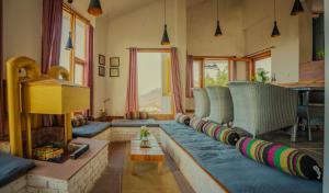 a living room with a couch and a fireplace at Revaant Retreat in Rāmgarh
