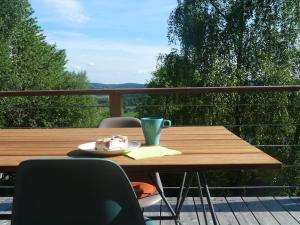 a wooden table with a plate of cake on a balcony at WaldNur in Neureichenau