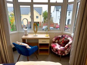 a bedroom with a desk and a chair and a mirror at Coastal Park Accommodation in Llanelli