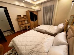 a hotel room with two beds and a television at فيلا إيجار في التجمع الخامس Vip Luxury home in Cairo