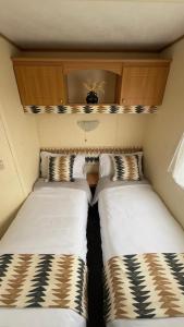 two beds sitting next to each other in a small room at Coastal Caravan in Solva in Haverfordwest