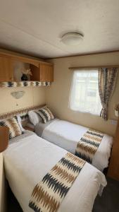a bedroom with two beds and a window at Coastal Caravan in Solva in Haverfordwest