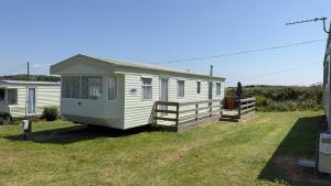 a small white caravan sitting in a yard at Coastal Caravan in Solva in Haverfordwest