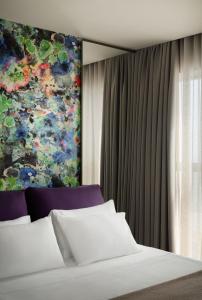 a bedroom with a bed and a painting on the wall at Chic & Cheeky Reside in Malta's Tallest Skyscraper in St Julian's +32 photos