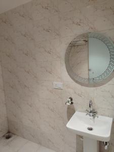 a bathroom with a sink and a mirror at Rivaz Hotel And Restaurant in New Delhi +1 photo