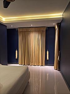 a bedroom with a bed and a curtain at Regal Suite by StayMehman in Rawalpindi