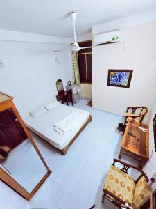 a bedroom with a bed and a mirror and chairs at Tài Phong in Ho Chi Minh City