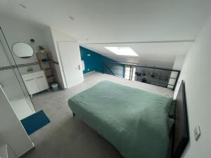a bedroom with a green bed in a room at Appartement au calme proche château de Launac, animaparc in Launac