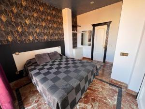 sypialnia z czarno-białym łóżkiem szachowym w obiekcie Apartamentos El Tiempo Madrid w Madrycie +37 zdjęć
