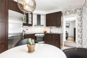 a kitchen with a white table with chairs and a kitchen with at Norrberge 2 in Sörberge