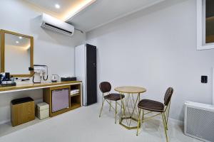 a room with a table and chairs and a mirror at sweet hotel in Gimcheon