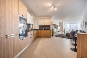 una cucina con mobili in legno e un soggiorno di Chic Downtown Hideaway a Msida