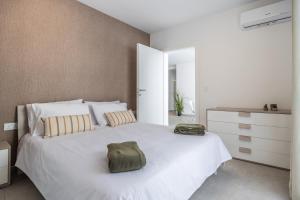 una camera da letto con un letto bianco con una borsa verde di Chic Downtown Hideaway a Msida