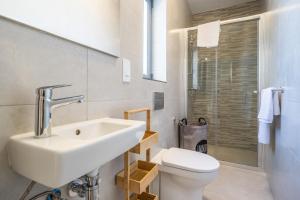 un bagno bianco con lavandino e WC di Chic Downtown Hideaway a Msida