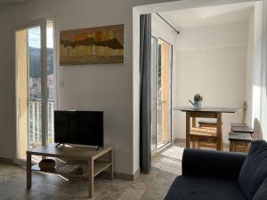 a living room with a couch and a tv at L'étape Bonifacienne in Bonifacio