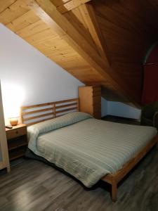 Un dormitorio con una cama y un techo de madera. en Mansarda Arel, en Turín