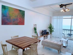 a dining room with a table and chairs and a painting at Glory Beach Duplex Ocean View - 8Pax 3BR & FREE Disney Hotstar in Port Dickson