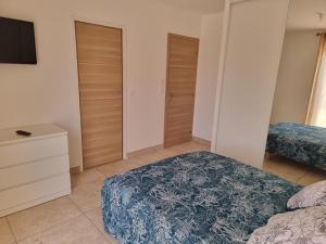 a bedroom with two beds and a flat screen tv at Perpignan Villa climatisée 4 personnes in Pia