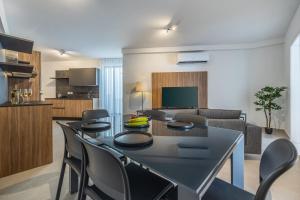 Un comedor y una sala de estar con mesa y sillas. en Modern Marvel Apartment with city views, en Msida