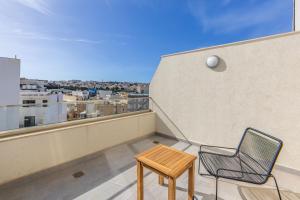 Un balcón con una silla y una mesa en Modern Marvel Apartment with city views, en Msida