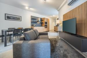 Una sala de estar con un sofá y un televisor de pantalla plana. en Modern Marvel Apartment with city views, en Msida