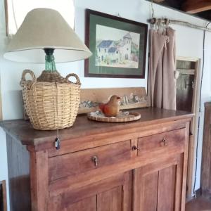 un tavolo con una lampada sopra un comò di Suite en cuadra pajar, casa Rural a Hoz de Jaca