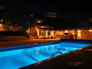 a person in a swimming pool at night at Beach house BellaVista with hot pool in Trogir