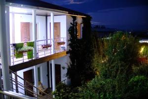 a white building with balconies and plants at night at Гостевой Дом В Гостях на Иссык-Куле in Cholpon-Ata