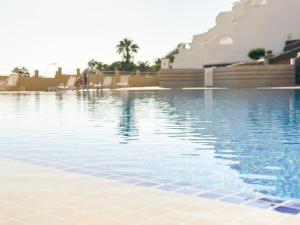 a swimming pool with blue water in a resort at Infinity Ocean View Suite in Adeje