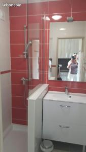 una donna che scatta una foto di un bagno con specchio di La Corniche d'Or à St Raphael a Saint-Raphaël