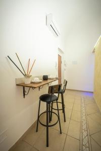 a table and two chairs in a room with a wall at Apulia lux in Taranto