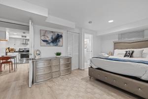 a bedroom with a large bed and a kitchen at Cozy 1-bedroom garden apartment in Silver Spring