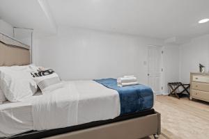 a white bedroom with a bed and a dresser at Cozy 1-bedroom garden apartment in Silver Spring