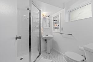 a white bathroom with a shower and a sink at Cozy 1-bedroom garden apartment in Silver Spring +10 photos