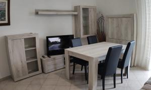a dining room with a table and chairs and a television at Apartment with balcony in Porto Santo Stefano 89 m² sea view in Porto Santo Stefano